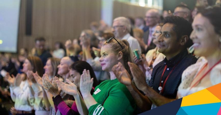 A crowd of people cheering at TEDxRRU