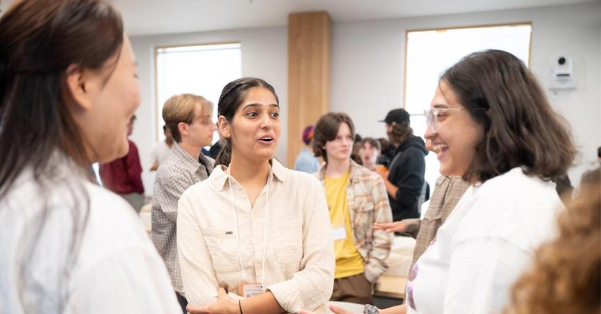 A room full of students gathered to learn about RRU's new undergraduate programming, scattered in a busy classroom.
