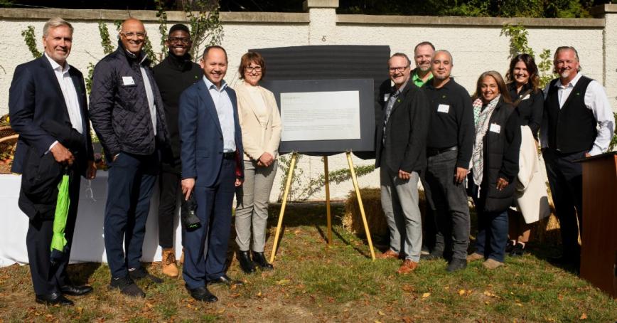 Representatives from TD and RRU stand next to commemorative plaque.