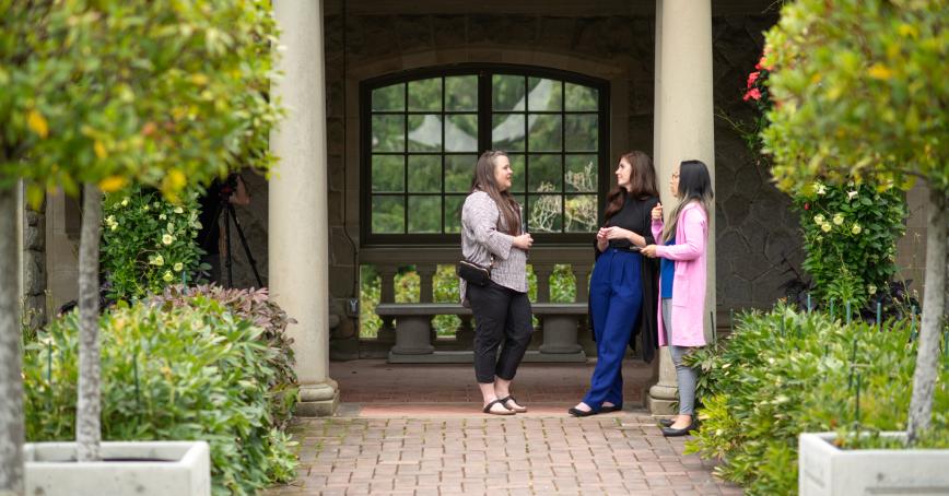 Three students chatting in garden.