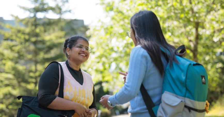 Two students speaking on university campus