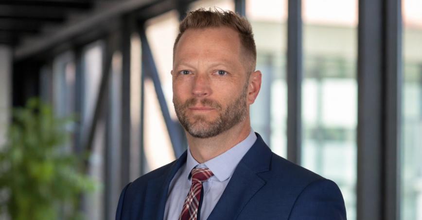 James Hanson wearing a suit and standing in a modern building
