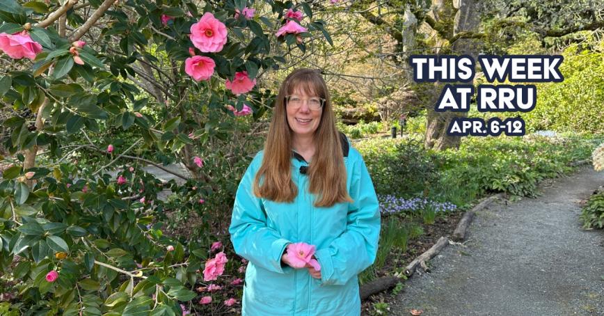 Woman standing in front of blossoming plant in garden