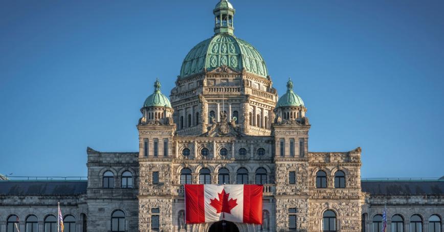 The top of the Victoria BC parliament building with a Canadian flag on it