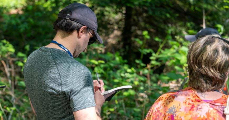 Students take notes while looking at greenery outside