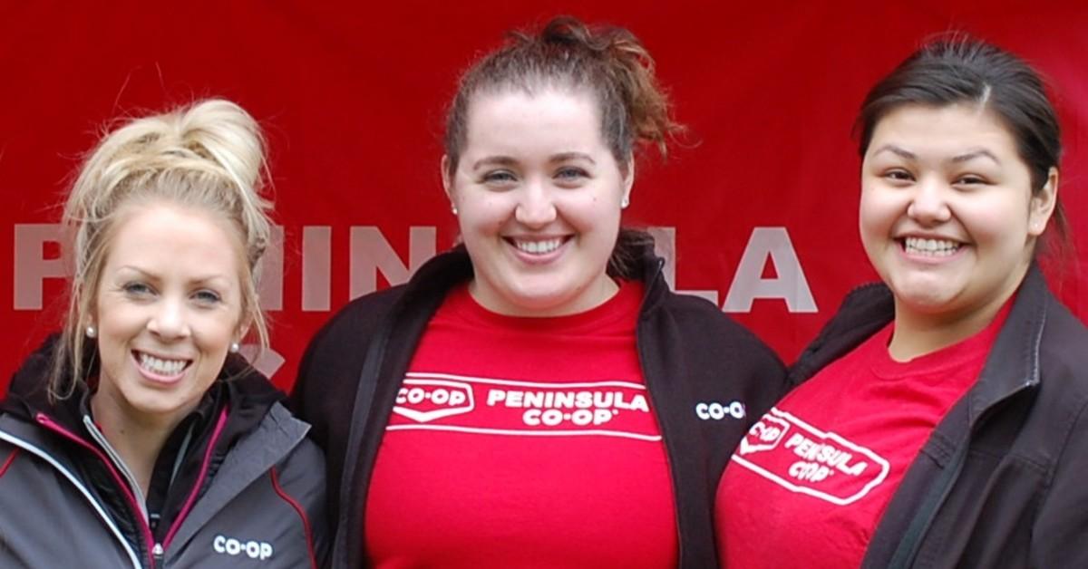 Three people in Penninsula Co-op wear stand together for a photo