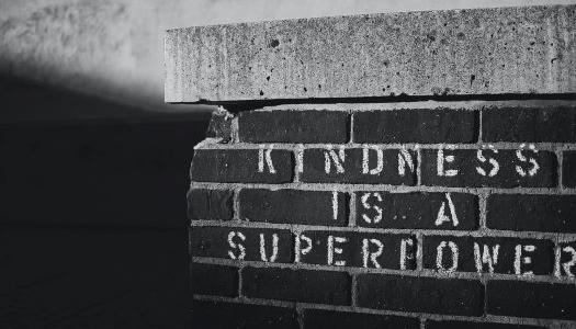 Words "kindness is a superpower" written on brick