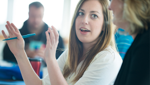 Student-gesturing-with-hands-to-another-student
