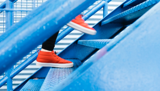 feet-in-orange-sneakers-stepping-up-blue-stairs
