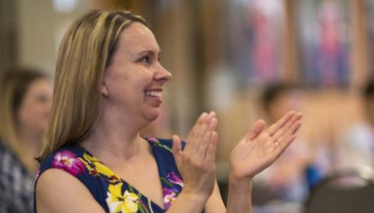 Picture of student in classroom clapping hands.