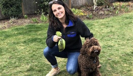 Person-kneeling-with-dog-waste-bag-and-brown-dog