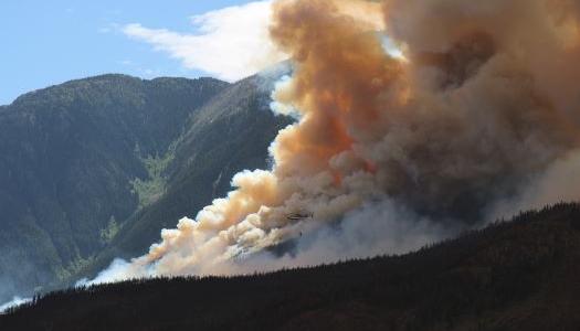 Fire and smoke seen on a mountain side.
