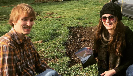 Two-students-kneeling-together-working-on-soil-project-in-field