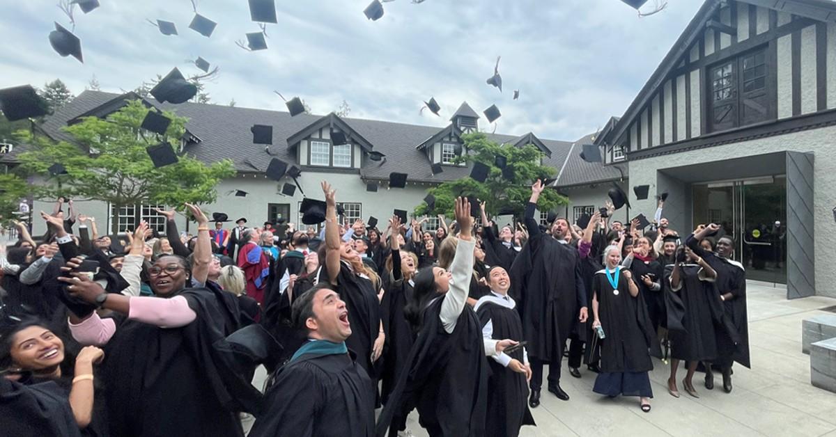 The spring 2023 graduates of the MAGL program at Royal Roads University throw up their hats in celebration