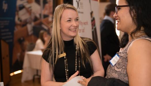 A student and employer are sharing information at a networking event.