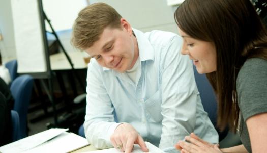 two-students-looking-at-textbook-together