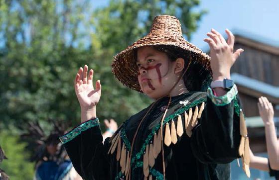 Land-welcome-person-with-cedar-woven-hat-and-hands-raised