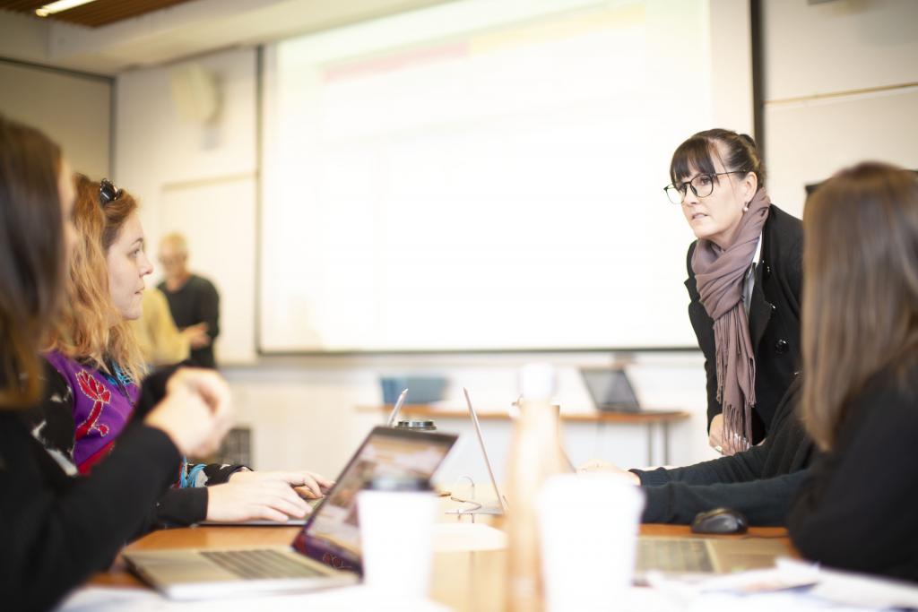 Students in classroom with large screen in background