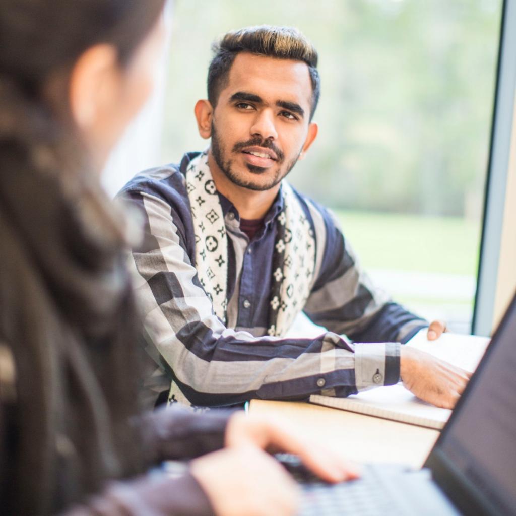 Two-students-talking-in-front-of-laptop