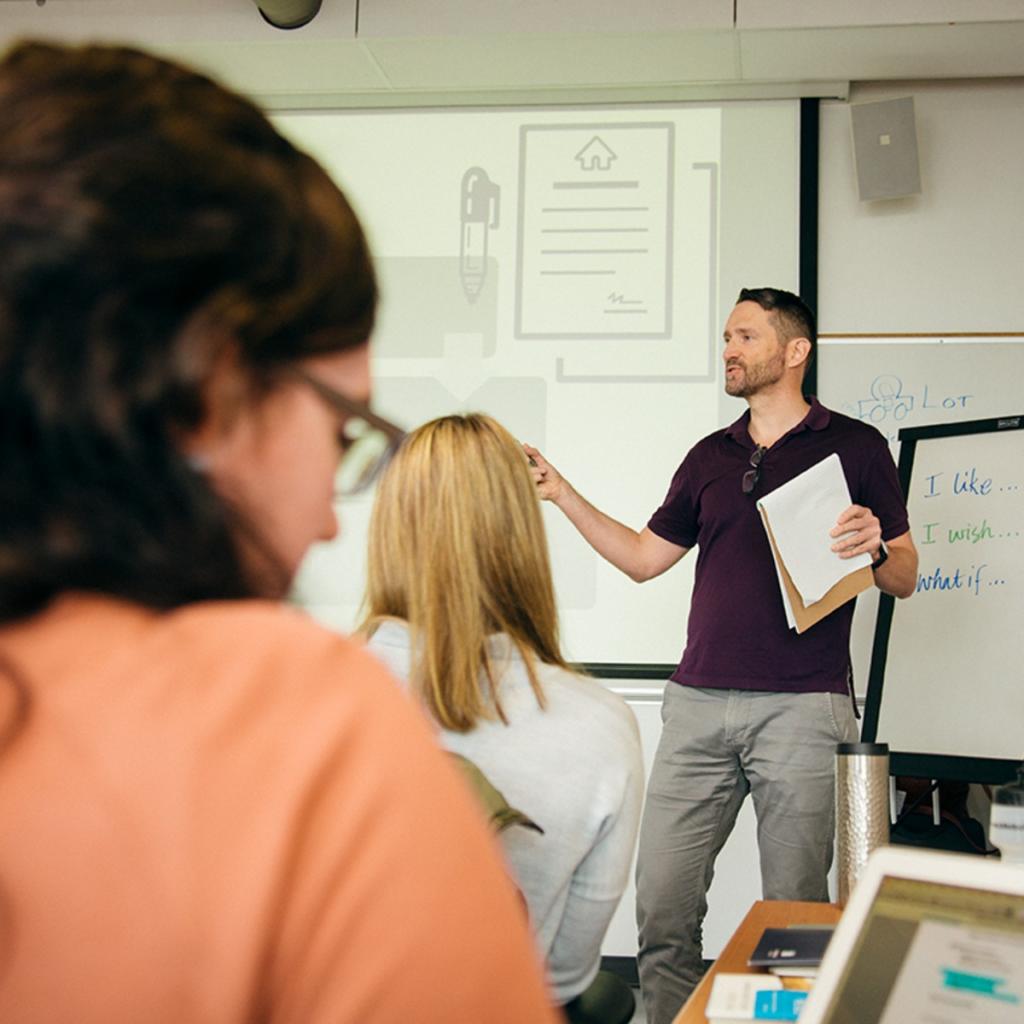 Instructor-with-whiteboard-and-flipchart-at-front-of-class