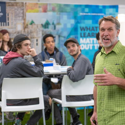 Students looking on while faculty member talks