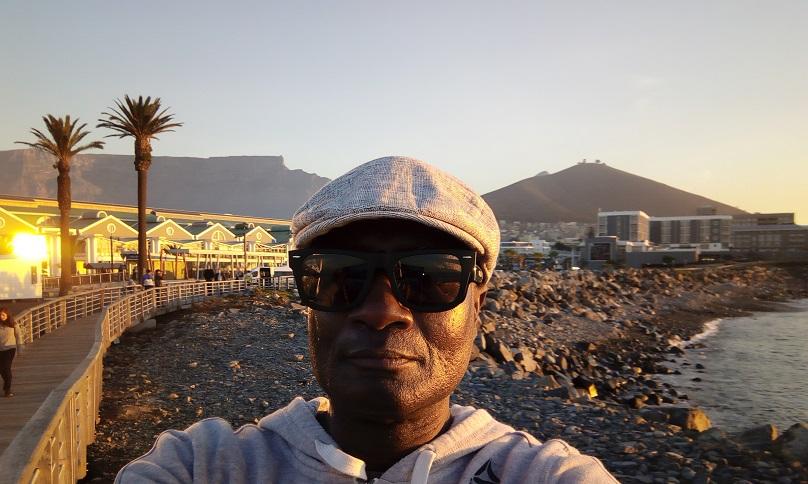 Person-with-sunglasses-at-sunset-at-the-V&A-waterfront-in-Cape-Town