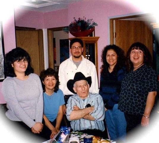Corrine Lewis-Coutre's family. Her grandfather is in the centre wearing a cowboy hat. The rest of the family is in a circle around him.