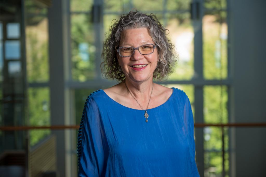 Prof. Frances Jorgensen, clad in a blue blouse, smiles while posing for a headshot.