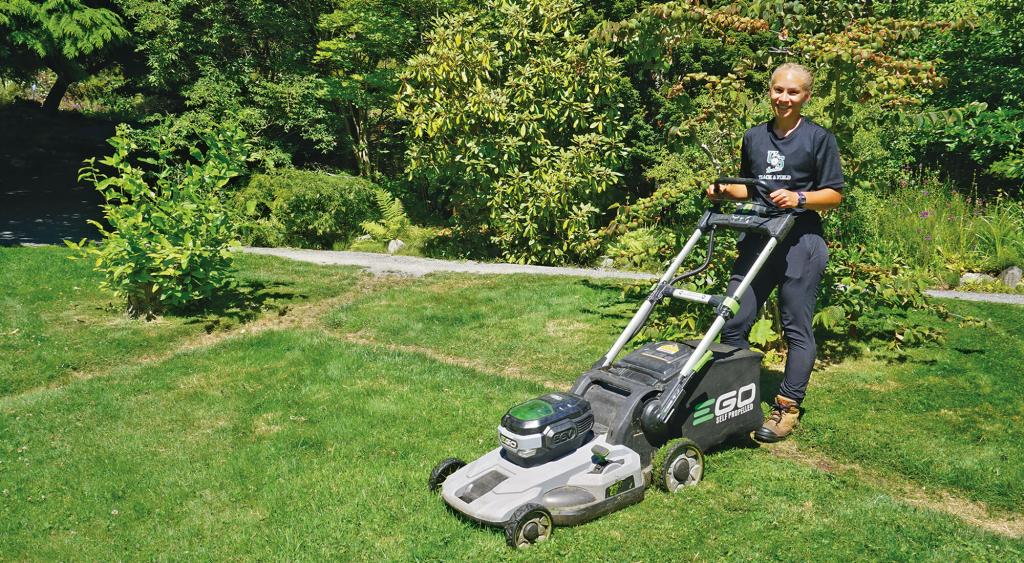 Courtney Weins mowing the lawn and smiling