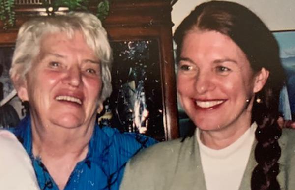 Close up of mother Wilma Colford and Daughter Mary Bernard standing in front of a hutch at a family event.