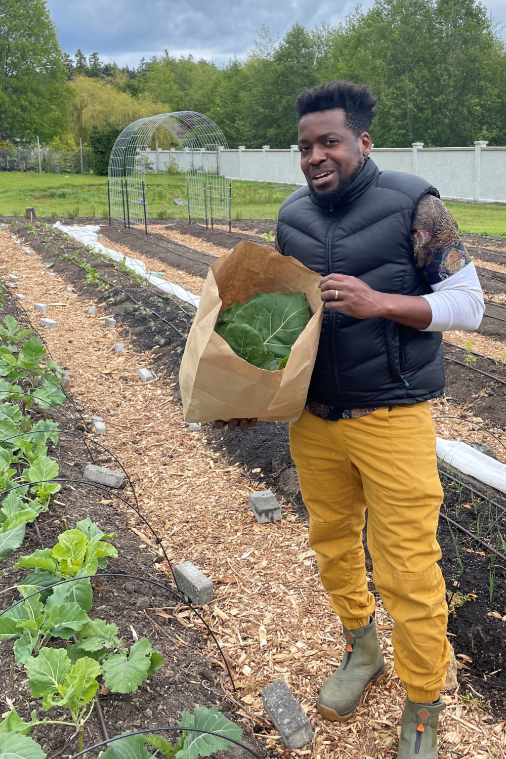 A man holds a bag of collarg greens harvested from the RRU Giving Garden.