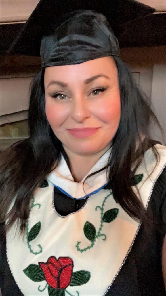 Shawna Yamkovy convocation photo in which she wears a mortarboard in front of the Hatley Castle fireplace