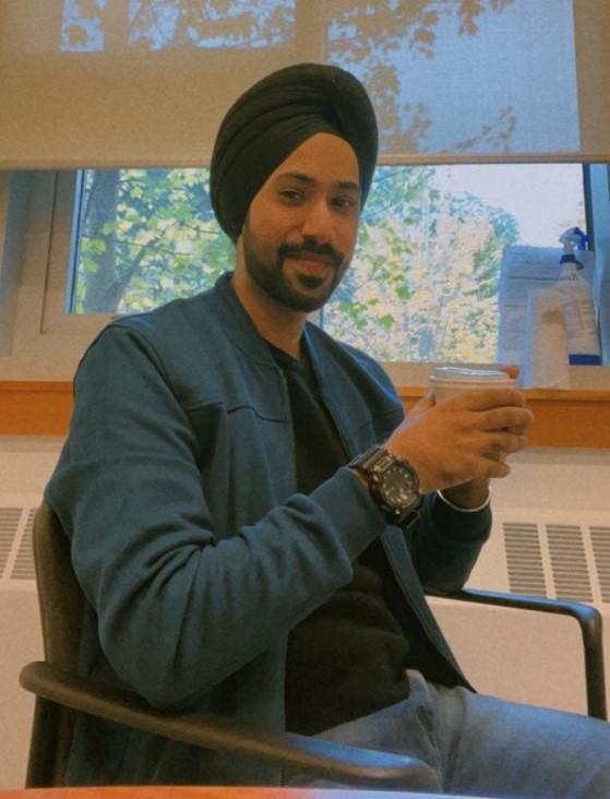 Beerinder Singh, MAIIC student at Royal Roads, sits in front of a window in a classroom.