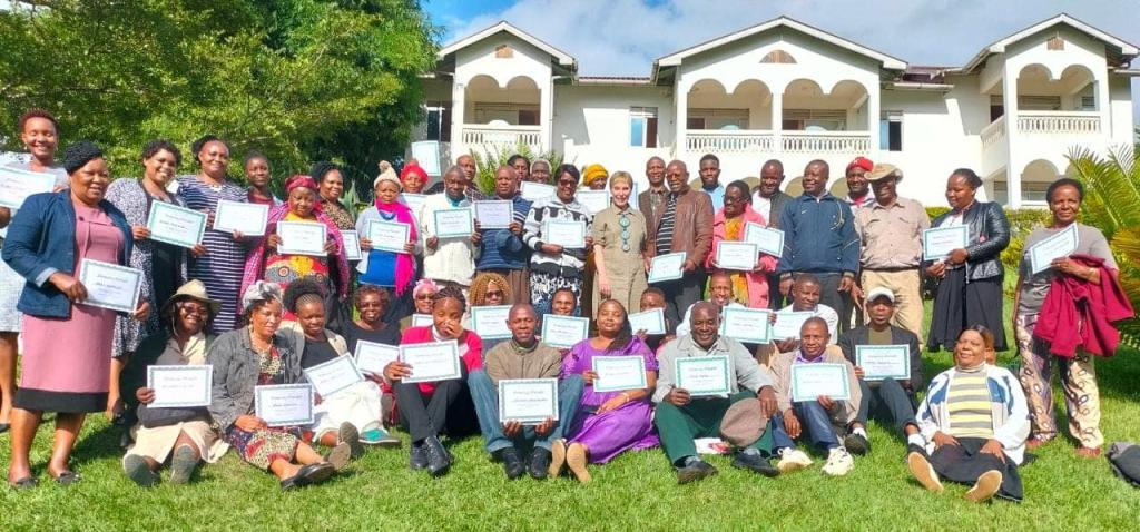 Workshop participants hold their certificates as homestay providers.