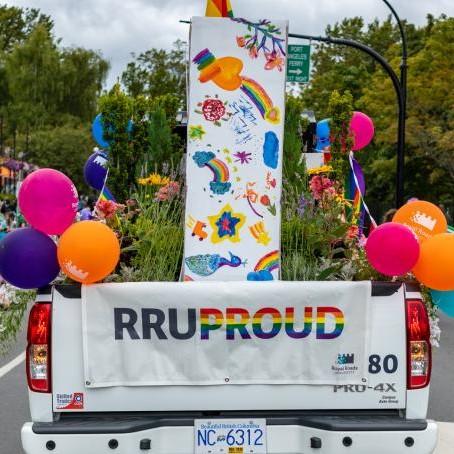 The back of an RRU truck with an RRU Proud banner, balloons and a bed full of flowers.