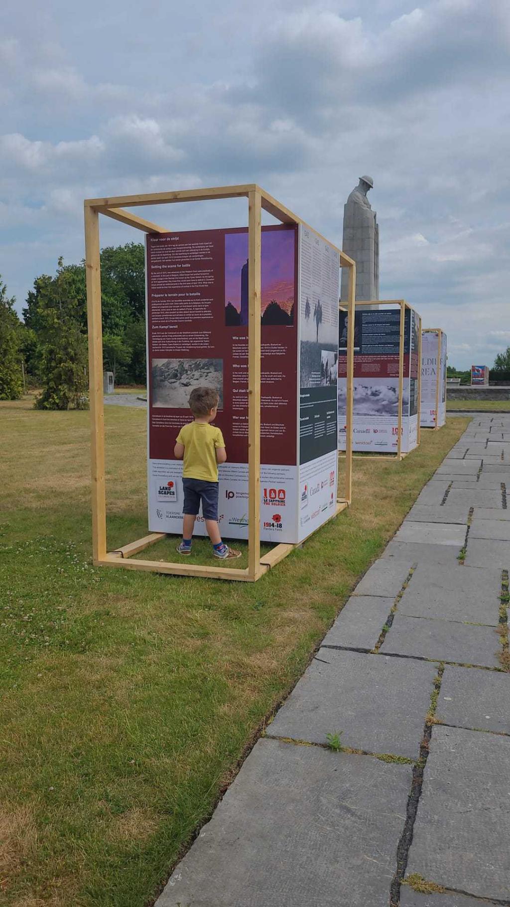 A child looks at the interpretive panel installed at the site of The Brooding Soldier monument