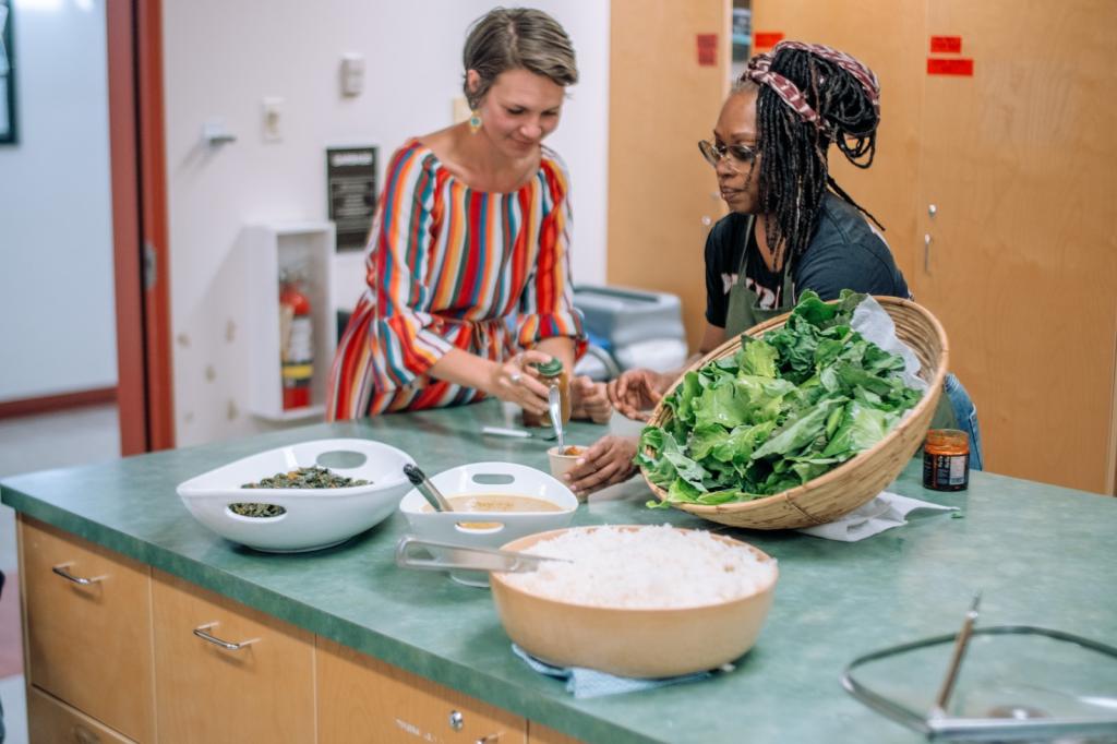 Two people cooking collard greens.