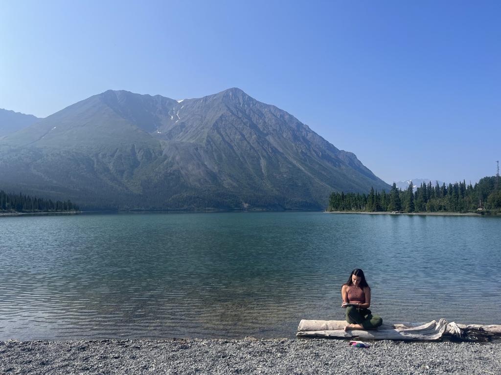 Grace (NWT) takes a moment to reflect on the shore of Mät’àtäna Män (Kathleen Lake) in Kluane National Park