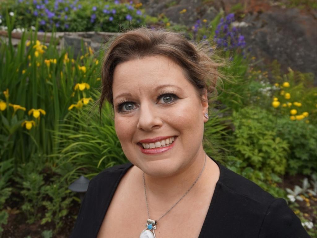 Teri Forster smiling in front of a garden