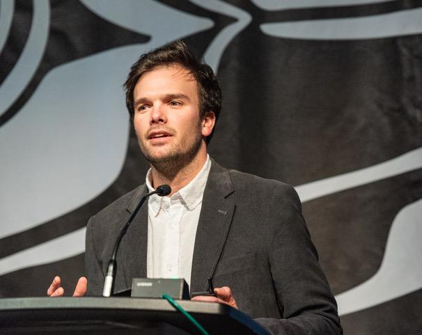 Raimundo Olivos speaks at a podium during the IMPACT Sustainability Travel and Tourism conference. 