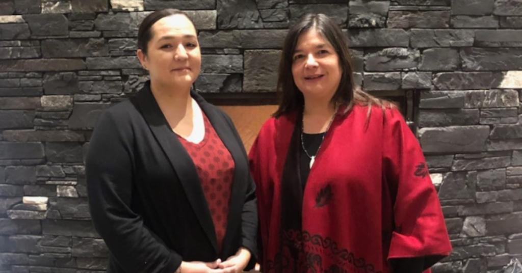 Two people pose in front of a fireplace representing the UAVS