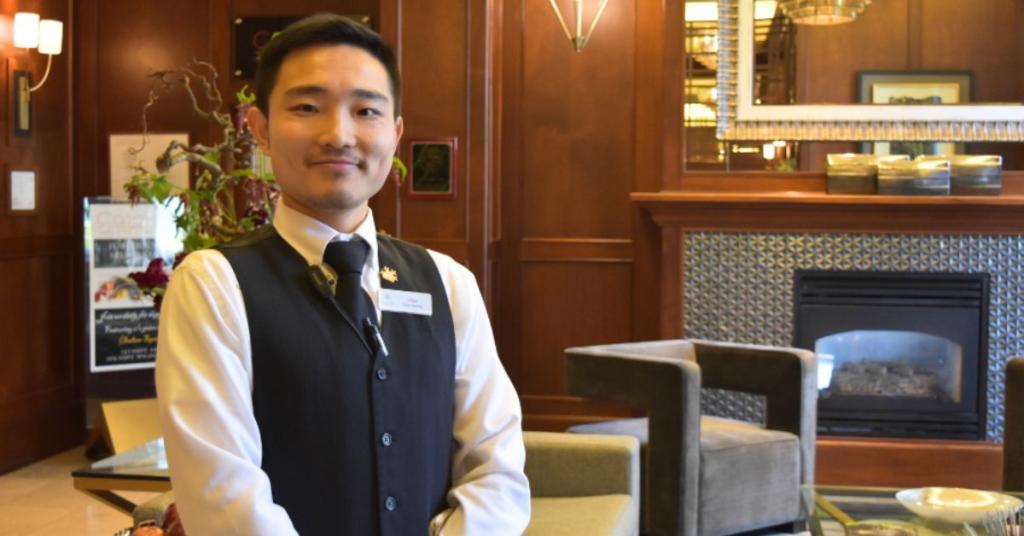 Chaoran Zhang poses smiling in a hotel in uniform