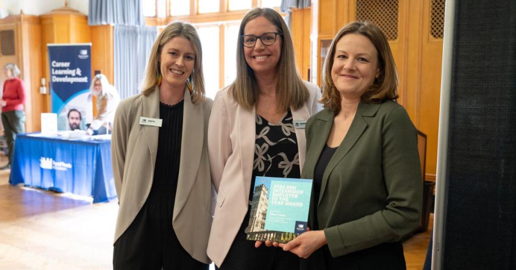 Photo of Robyn Booth and Heather McDonald awarding a plaque to a representative of Wilson's Group
