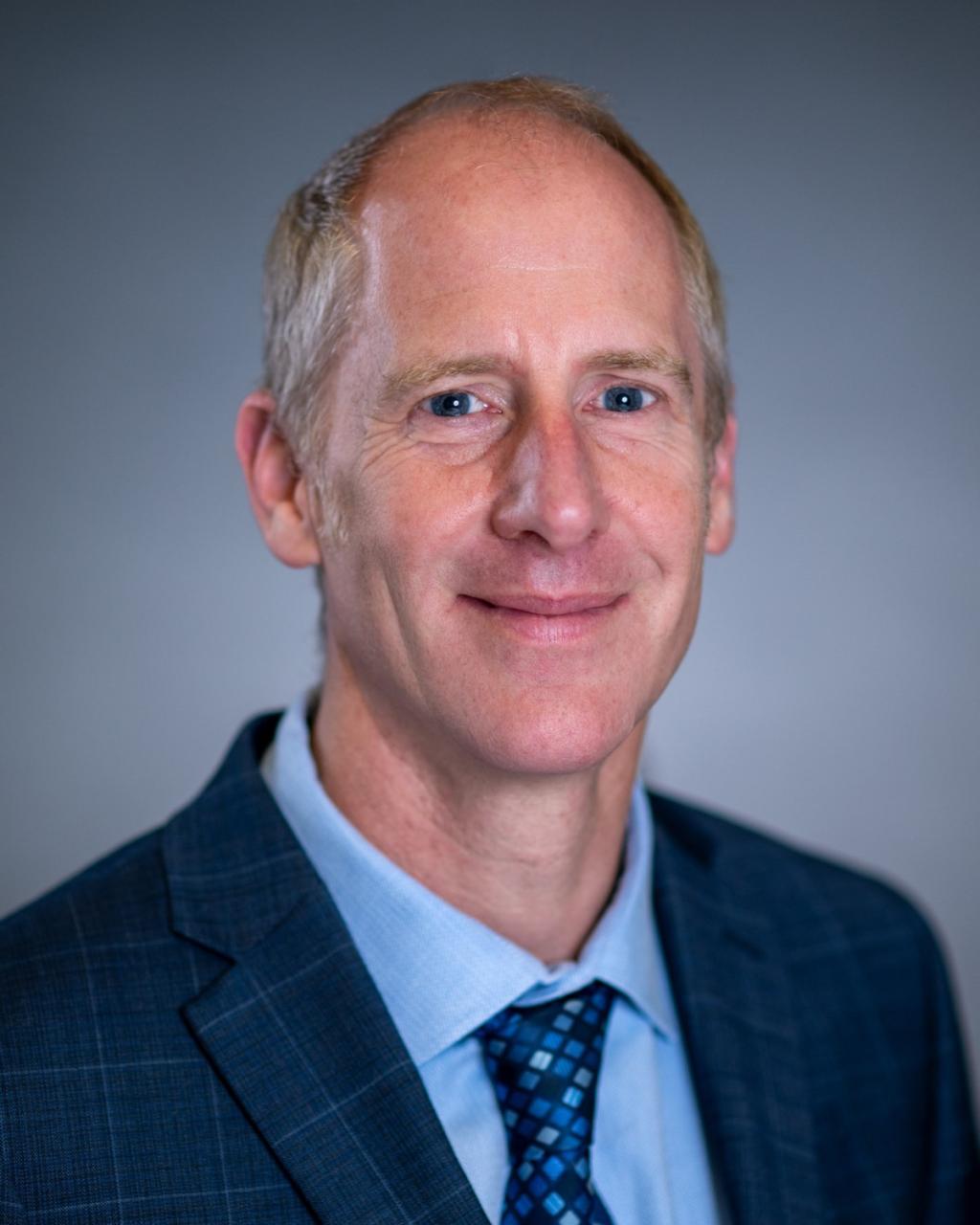 Alex Kortum in a suit and tie.