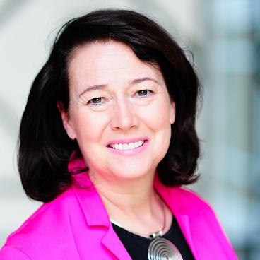 Janet Austin smiling wearing a casual dress