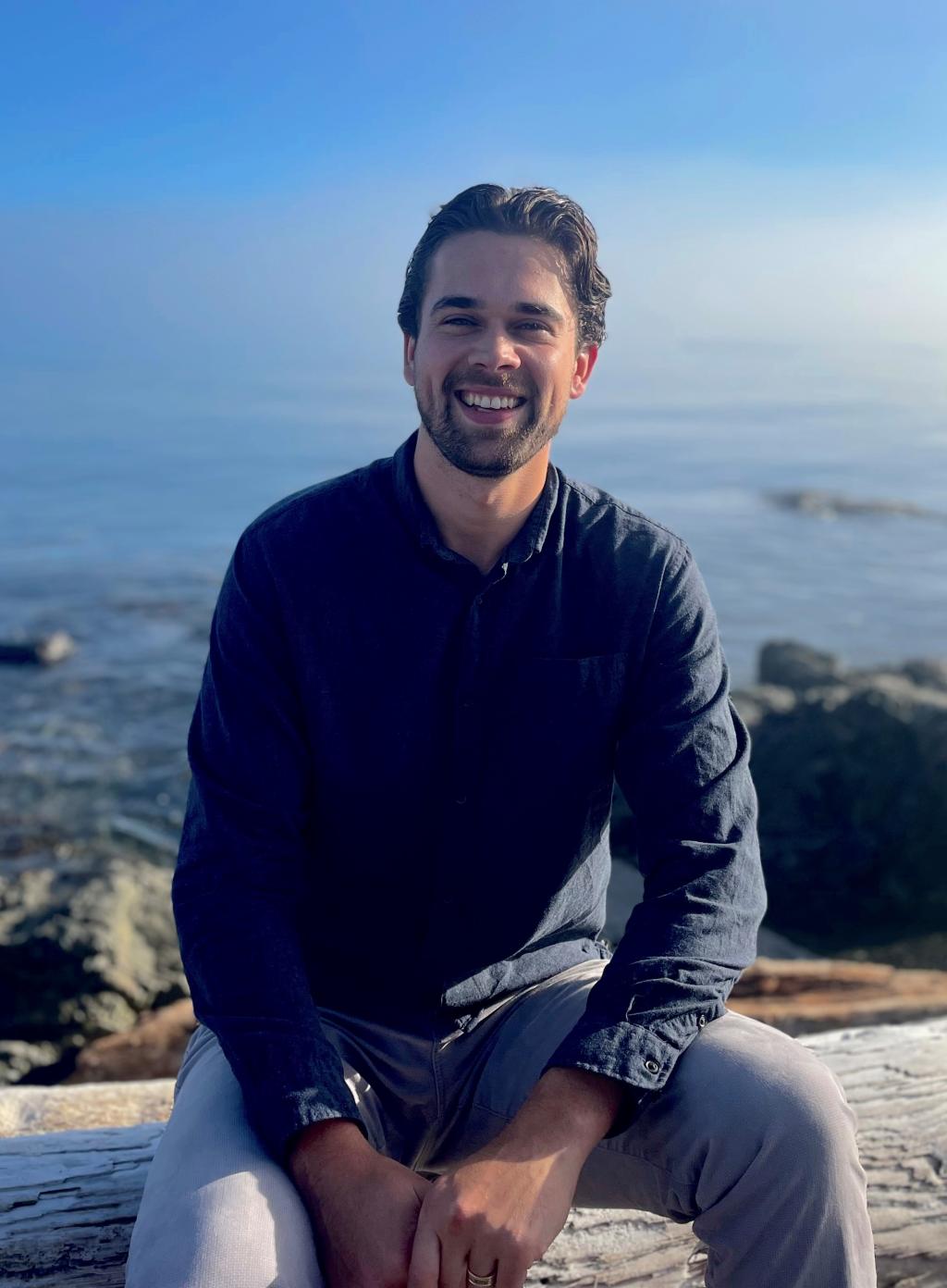Photo of Isaac sitting at the beach