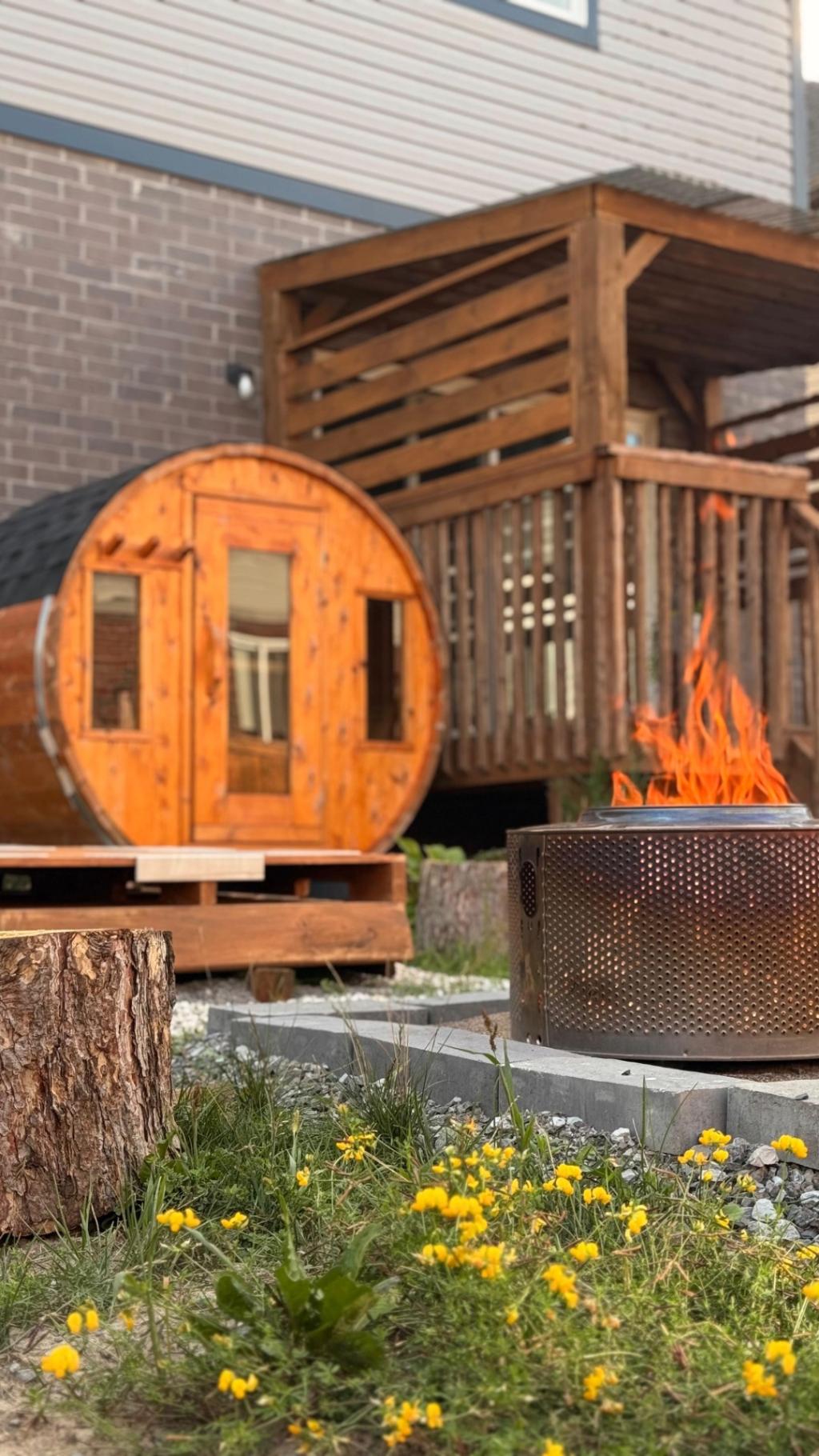 A space with a small sauna, a wood-burning fire and a stump