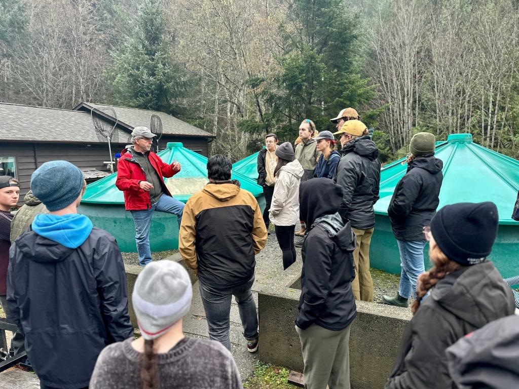 Students tour large tanks that house salmon at the fish hatchery
