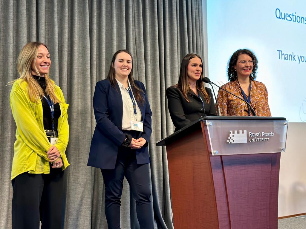 Four women give a presentation on a stage.