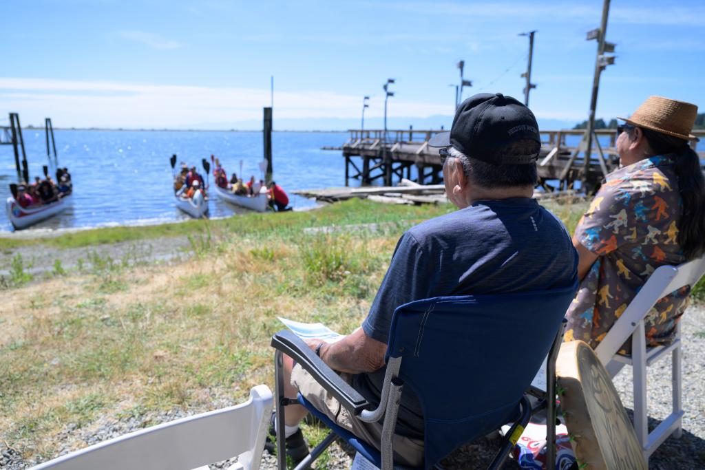 Butch Dick and Bradley Dick welcome canoes to the shore of Esquimalt lagoon